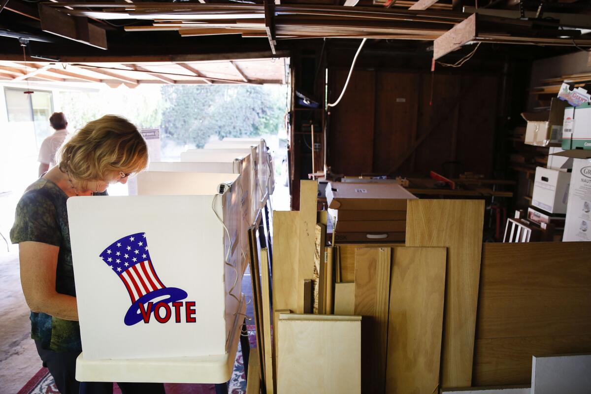 Election worker Jan Roddick casts her ballot Tuesday at a polling place in a home's garage in unincorporated Los Angeles County.
