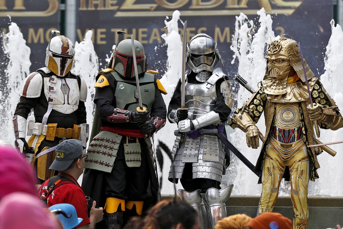 A group of cosplayers dressed as various characters from the Star Wars franchise, pose outside Wondercon 2023 in Anaheim.