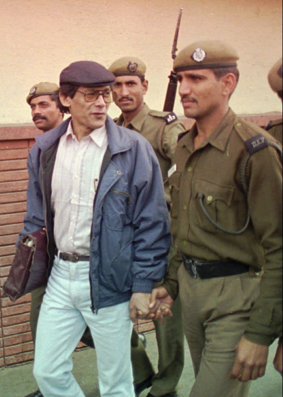 Charles Sobhraj is escorted by police to a court in New Delhi, India, for a bail hearing in 1997.