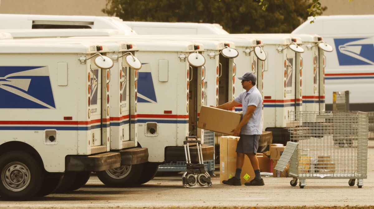 Mail carriers load their trucks at the U.S. Postal Service office in Van Nuys in September 2020.