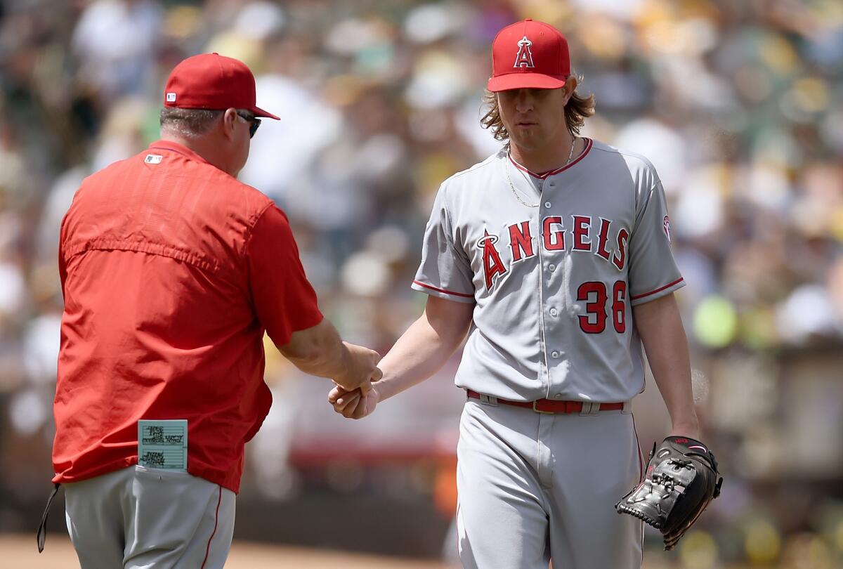 Angels Manager Mike Scioscia takes the ball from pitcher Jered Weaver, taking him out of the game against the Oakland Athletics on June 20.