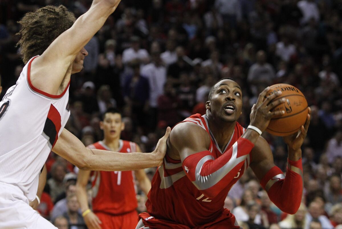 Rockets center Dwight Howard looks to score against Trail Blazers center Robin Lopez in the second half of their playoff game Friday night in Portland.