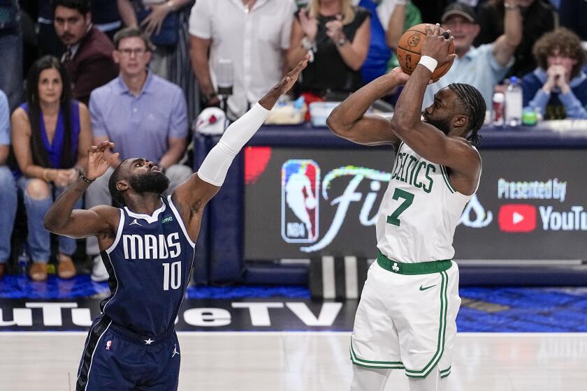 Boston Celtics guard Jaylen Brown (7) shoots against Dallas Mavericks forward Tim Hardaway Jr. (10) during the second half in Game 3 of the NBA basketball finals, Wednesday, June 12, 2024, in Dallas. The Celtics won 106-99. (AP Photo/Tony Gutierrez)