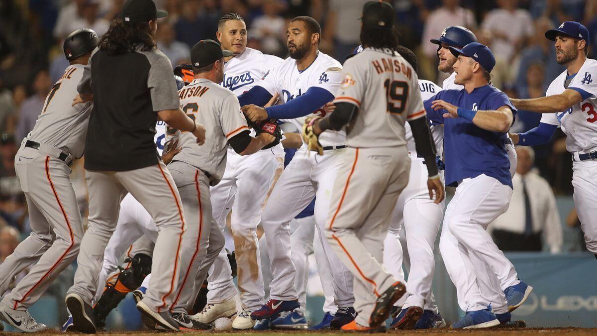 Dodgers and San Francisco Giants players and coaches step in after Dodgers' Yasiel Puig shoved Giants catcher Nick Hundley at the plate in the bottom of the seventh inning against at Dodger Stadium on Tuesday.