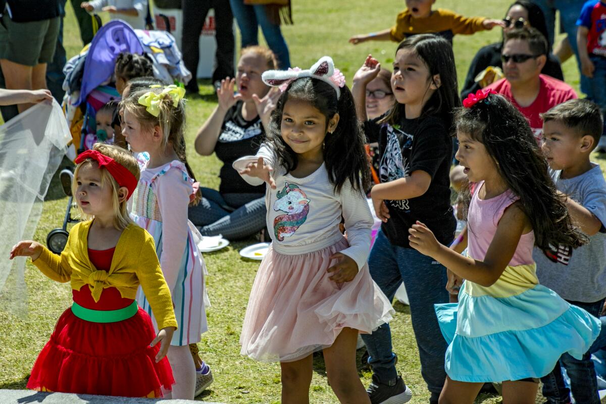 Carsyn Palacios, 4, left, with 6-year-old Patricia Vasquez and Camilla Ramos, 5, dance Saturday at Costa Mesa's Lions Park.