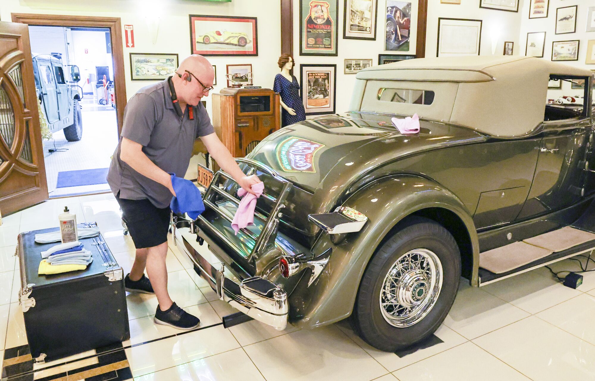 Restoration specialist Michael Howem polishes the chrome on a 1934 Packard 