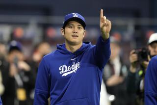 Los Angeles Dodgers designated hitter Shohei Ohtani gestures as he warms up.