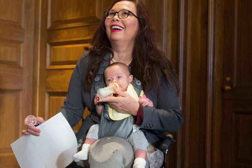 Mandatory Credit: Photo by MICHAEL REYNOLDS/EPA-EFE/REX/Shutterstock (9760435b) Tammy Duckworth Female US Senators hold a news conference to discuss women's reproductive rights, Washington, USA - 12 Jul 2018 Democratic Senator from Illinois Tammy Duckworth holds her child, Maile, while joining female US Senators at a news conference to discuss women's reproductive rights, on Capitol Hill in Washington, DC, USA, 12 July 2018. A bipartisan group of female US Senators held the news conference to voice their opposition to the confirmation of Brett Kavanaugh as a US Supreme Court Justice. The Senators claim that President Donald J. Trump's Supreme Court Justice nominee could help reverse the landmark 1973 ruling on abortion, Roe versus Wade. ** Usable by LA, CT and MoD ONLY **