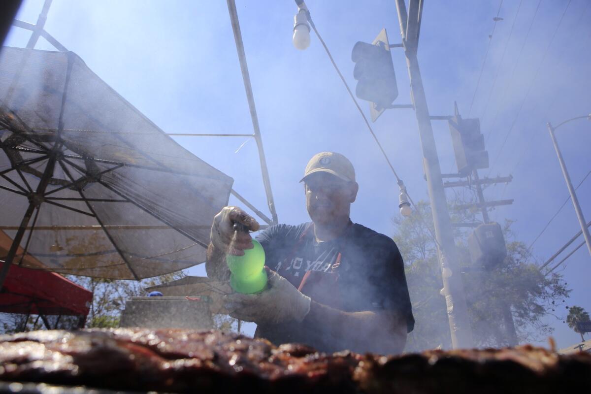 Chef Juan Alvarez sprays marinade on sizzling Korean barbecue ribs at the L.A. Korean festival Sunday afternoon.
