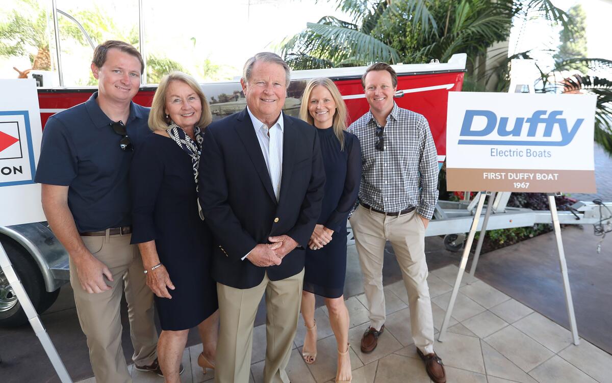 Marshall "Duffy" Duffield, center, stands with his family next to his first "Duffy" electric boat on Thursday.