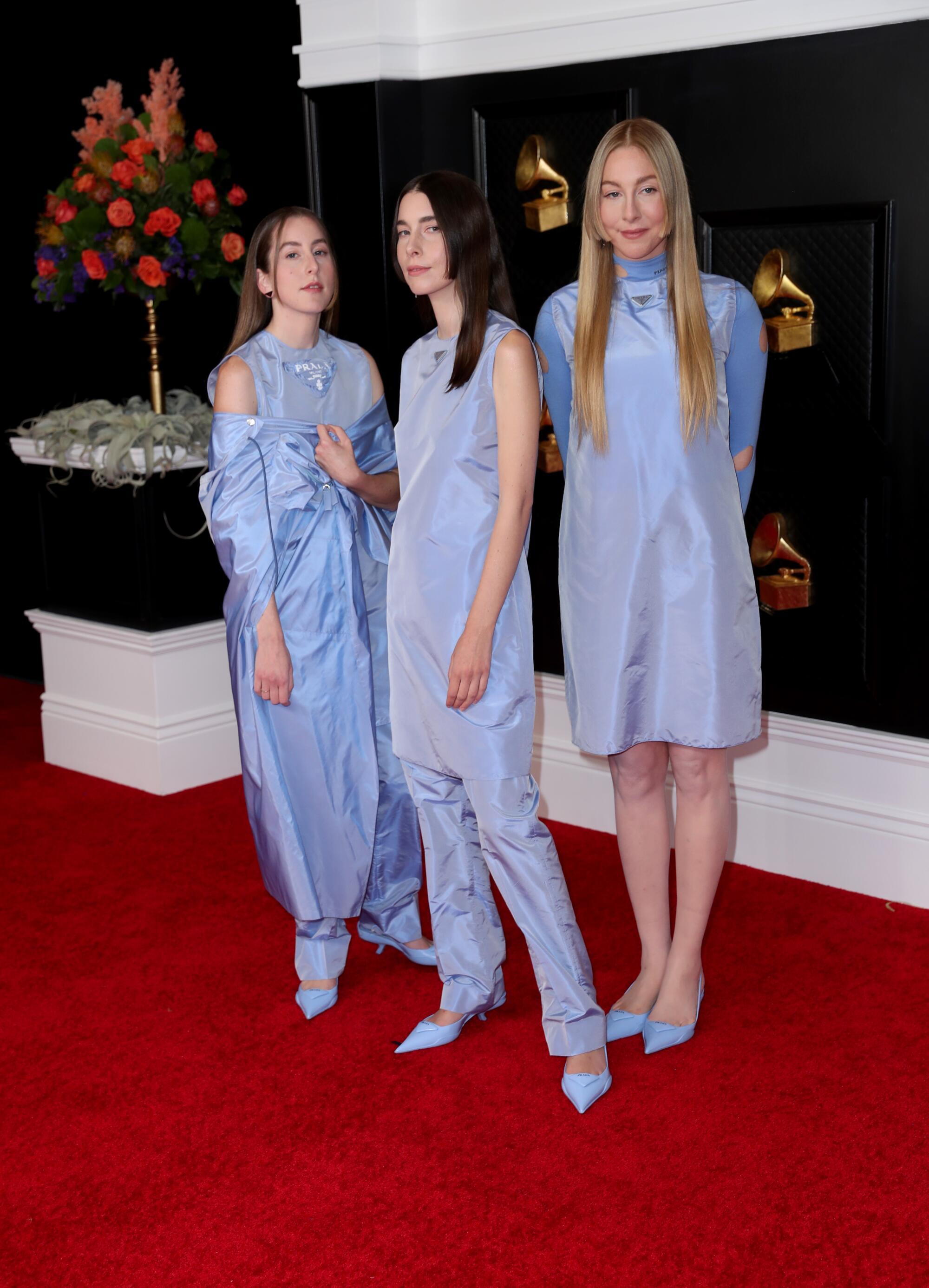 The three Haim sisters in coordinating pale blue outfits on the red carpet at the 63rd Grammy Awards.