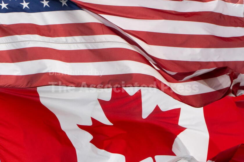 The flags of Canada and the United States fly over a stadium in Ottawa, Saturday, Sept. 12, 2026. (Adrian Wyld/The Canadian Press via AP)
