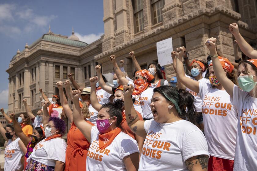 FILE- In this Wednesday, Sept. 1, 2021, file photo, women protest against Texas' restrictive abortion law at the Capitol in Austin, Texas. A federal judge on Friday, Oct. 1, 2021, will consider whether Texas can leave in place the most restrictive abortion law in the U.S., which since September has banned most abortions and sent women racing to get care beyond the borders of the nation's second-largest state. (Jay Janner/Austin American-Statesman via AP)