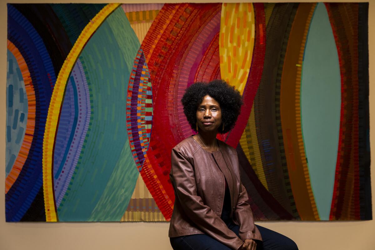 June Edmonds poses for a portrait in front of her painting, "Ufufuo," at the Los Angeles Municipal Art Gallery at Barnsdall park.