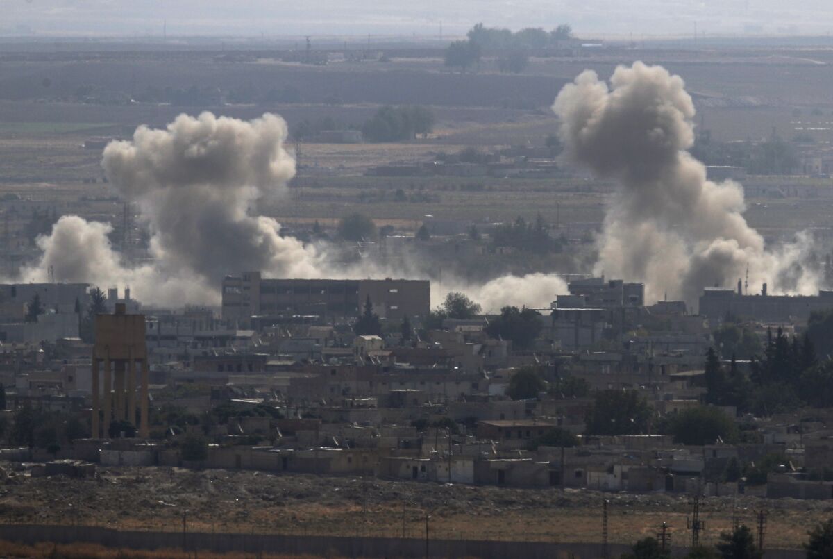 Smoke and dust billows from targets in Ras al-Ayn, Syria, caused by bombardment by Turkish forces, on Tuesday.