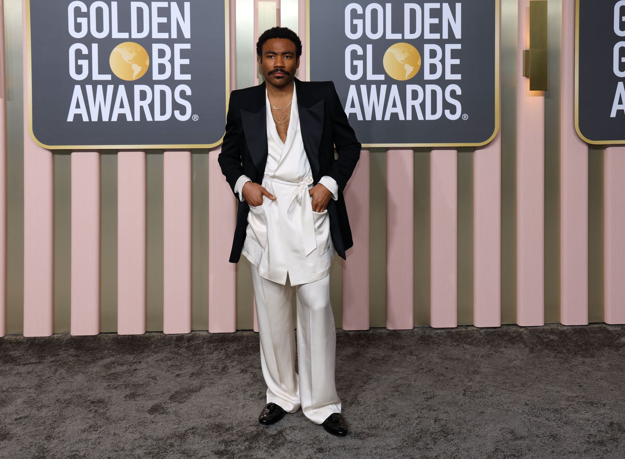 Donald Glover poses in a silk ensemble at the Golden Globes.