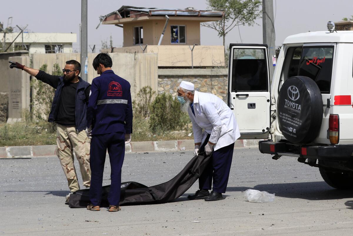 Afghan security officials move the body of an alleged suicide bomber on Aug. 7.