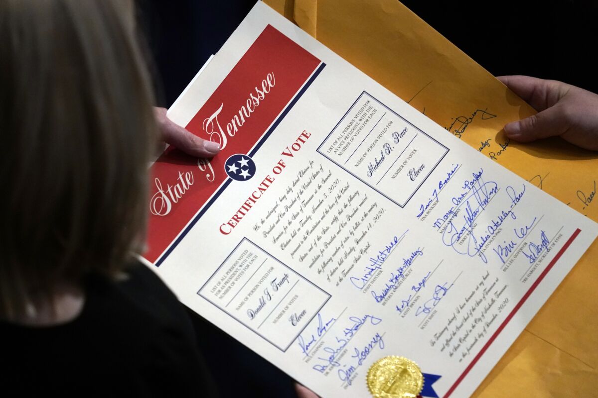 FILE - Staff members hold the certification of Electoral College votes from Tennessee during a joint session of the House and Senate to confirm Electoral College votes at the Capitol, early Jan 7, 2021, in Washington. Former President Donald Trump's relentless, false claims about the 2020 presidential election have sparked fresh urgency in Congress for changing the Electoral Count Act. (AP Photo/Andrew Harnik, File)