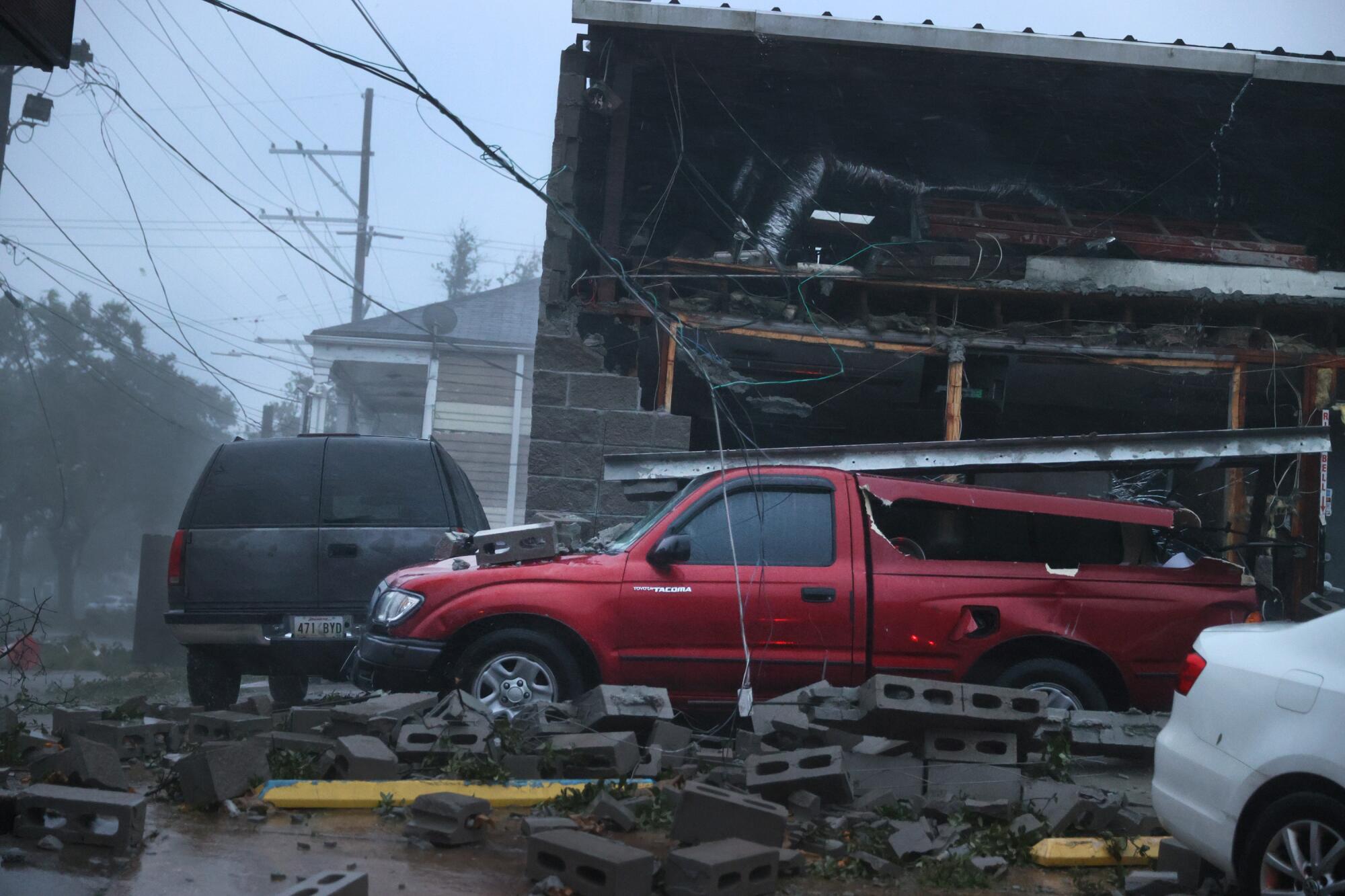 Vehicles are damaged after the front of a building collapsed.