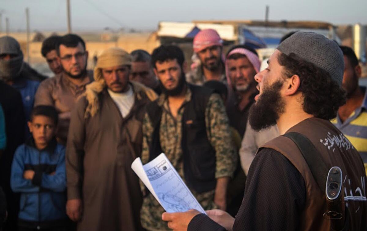 Un miembro del grupo Estado Islámico conocido como "Hisba", derecha, lee un veredicto dictado por un tribunal islámico en la ciudad de Al Raqa, Siria.(Sitio Extremista via AP, archivo)