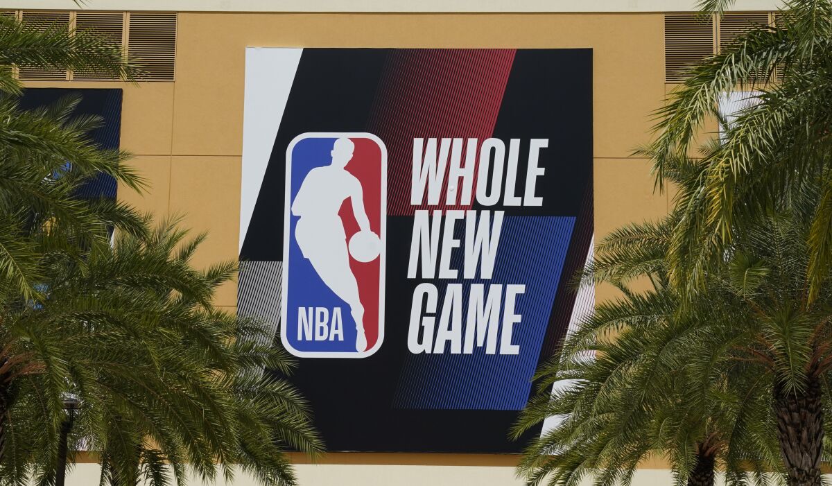 The NBA logo is displayed outside a basketball arena in Lake Buena Vista, Fla.