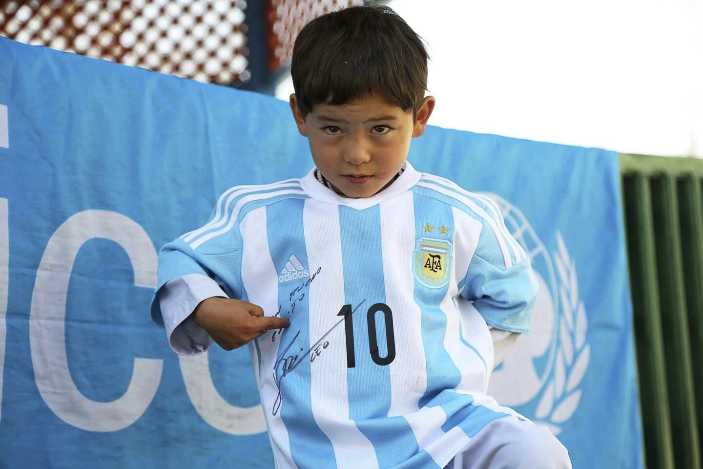 El niño afgano de 5 años, Murtaza Ahmadi, fan del delantero argentino del Barcelona Lionel Messi, mientras posa con una camiseta de la selección argentina firmada por el astro argentino en Kabul (Afganistán). Murtaza se hizo famoso por unas fotos en las que aparecía vestido con una bolsa de plástico que simulaba ser una camiseta de la selección argentina, y ha cumplido su sueño de tener algo de su ídolo ya que ha recibido la camiseta y un balón firmado por Messi.