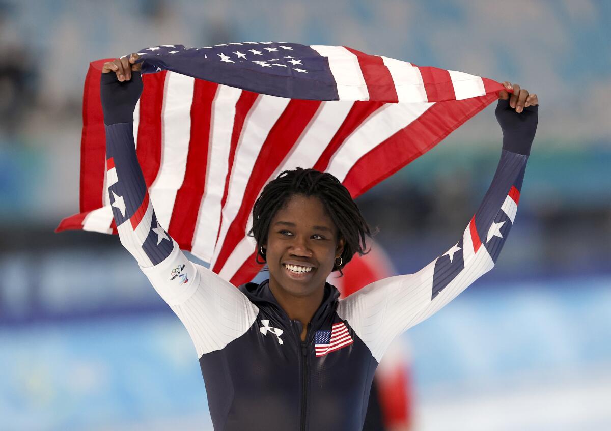 U.S. speedskater Erin Jackson takes a victory lap with an American flag.