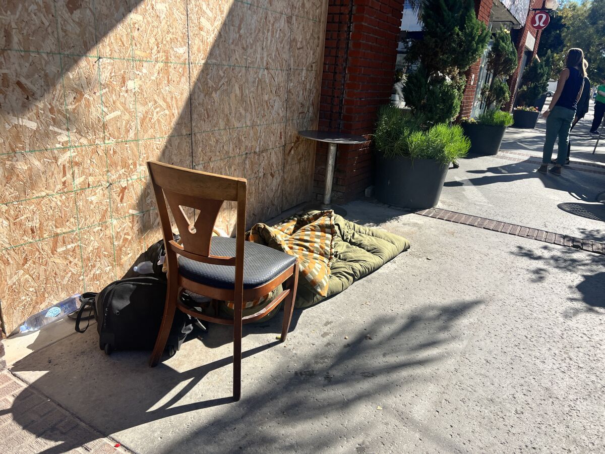 A homeless person's sleeping bag lies on the sidewalk outside a restaurant on Girard Avenue in La Jolla. 