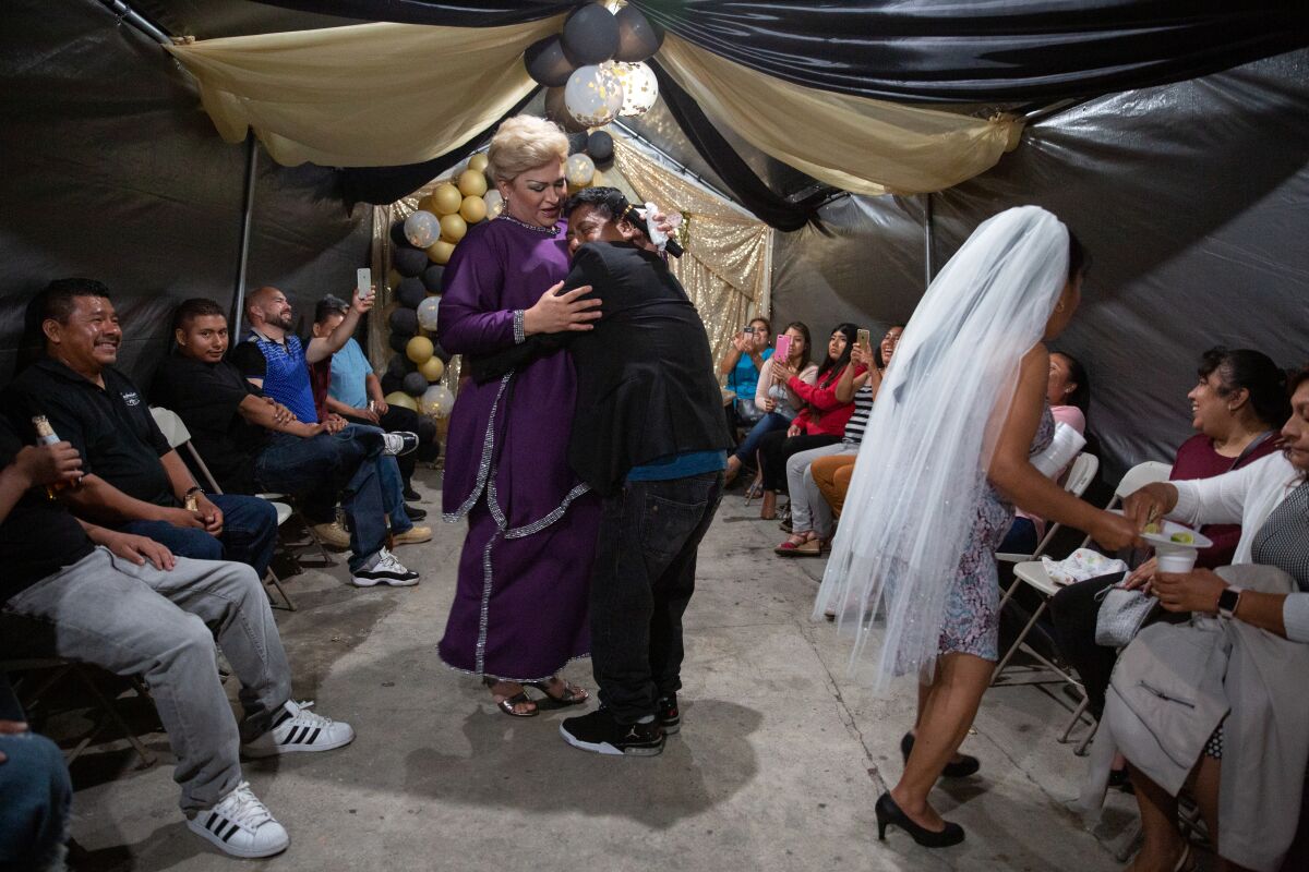 In one of Arlene Mejorado's photos for her "Caricias" project, a groom-to-be holds Barbara Towne while she performs as Paquita la del Barrio at a bachelor-bachelorette party in Compton. Towne is a transgender woman from Honduras who performed as three different divas at the party. 