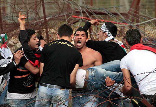 Protesters carry a Palestinian man