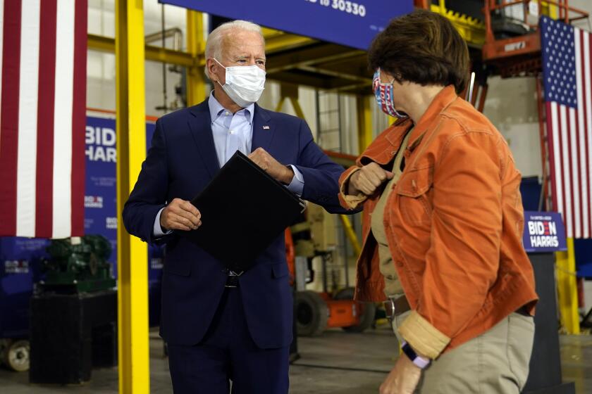 Democratic presidential candidate former Vice President Joe Biden elbow bumps Sen. Amy Klobuchar, D-Minn., after he spoke at a union training center in Hermantown, Minn., Friday, Sept. 18, 2020. (AP Photo/Carolyn Kaster)