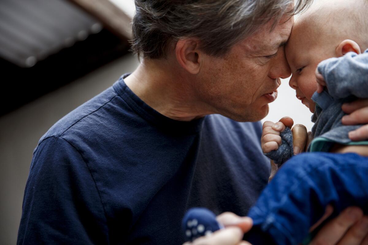 Berggruen cuddles his son Alexander following a passport photo session in west Los Angeles on April 20.