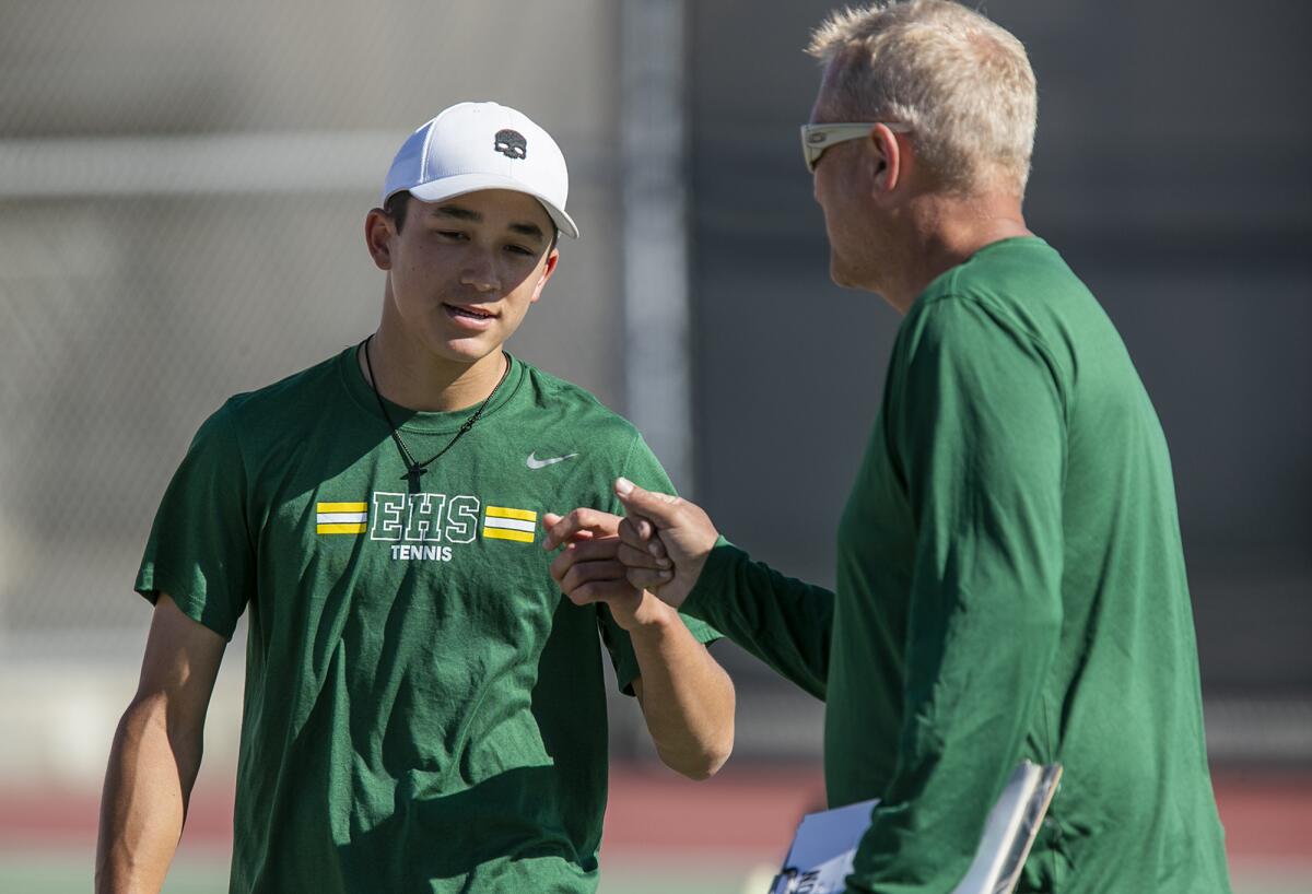 Edison's Kai Stolaruk fist bumps head coach Dave Lemons during a match against Huntington Beach on Thursday.