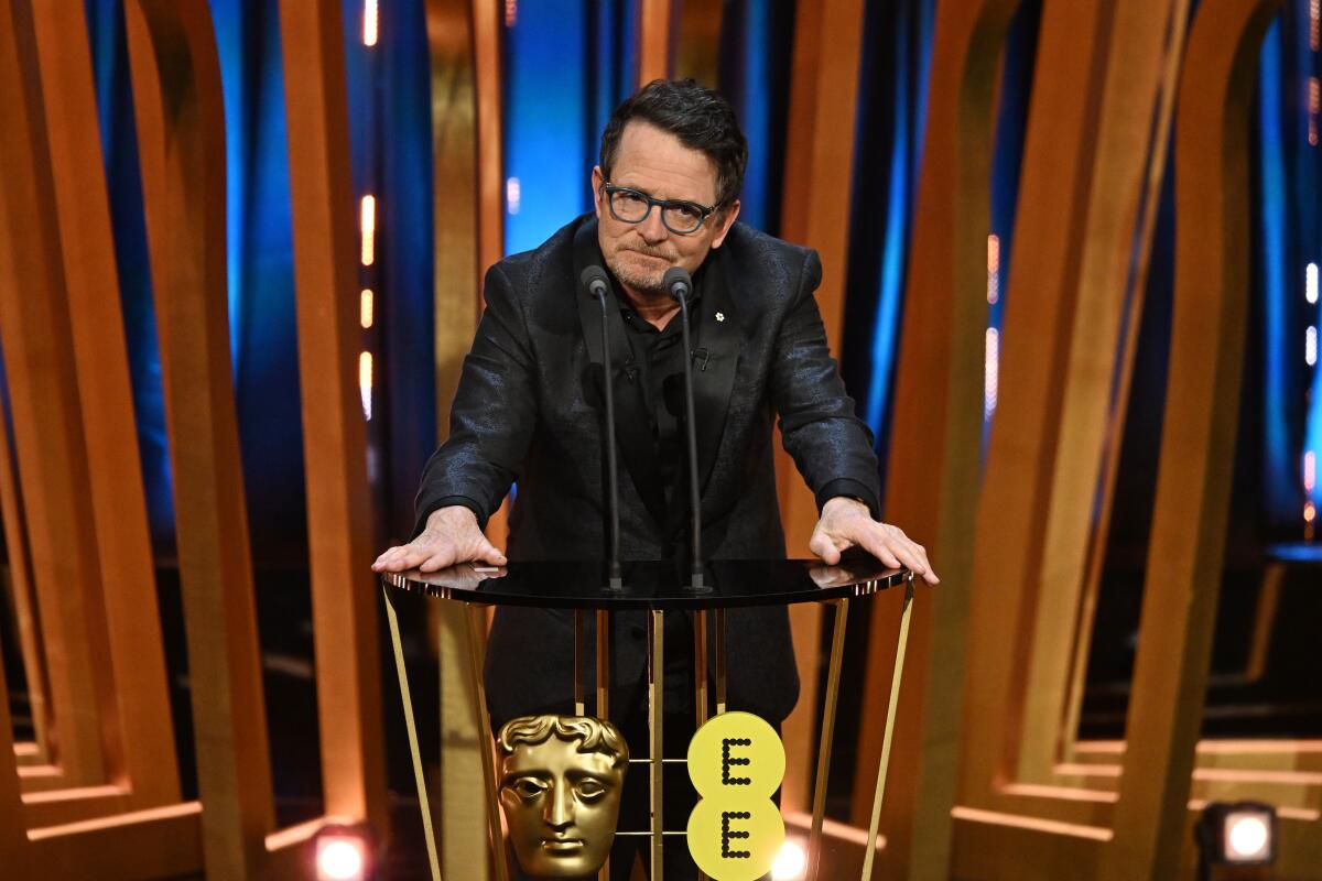 Michael J. Fox stands at a lectern.