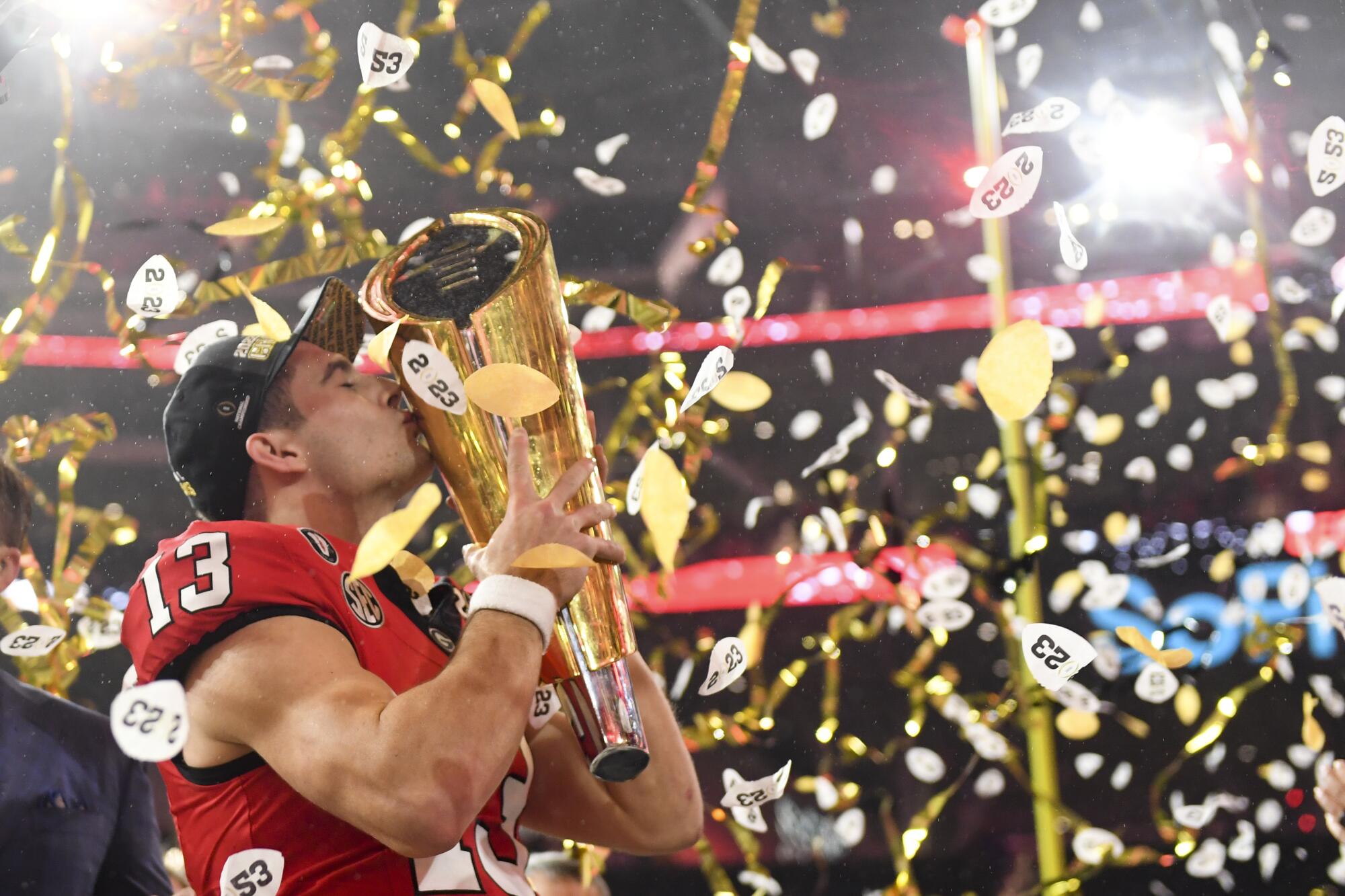 Georgia quarterback Stetson Bennett celebrates with the national championship trophy after the Bulldogs' win over TCU.