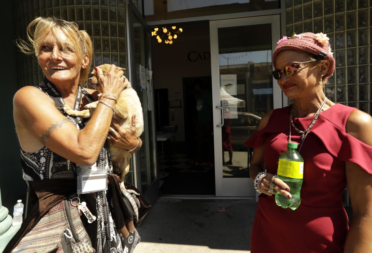 Teresa Robles, left, and Dixie Moore mingle outside their Project Roomkey hotel in Venice last month.