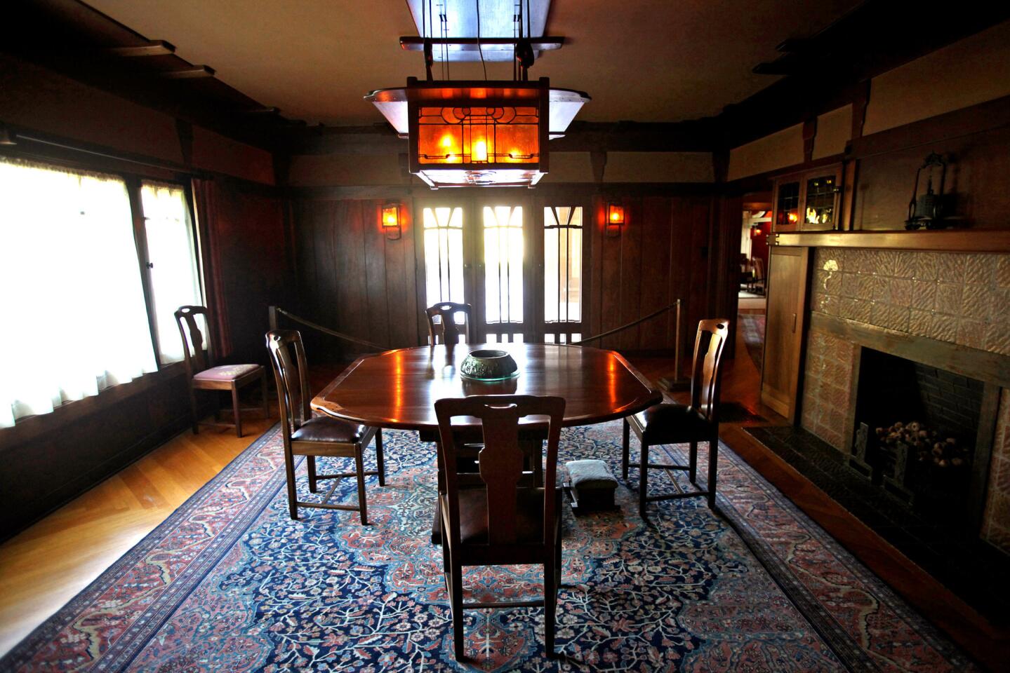 The dining room features an art glass light fixture and built-in cupboards.
