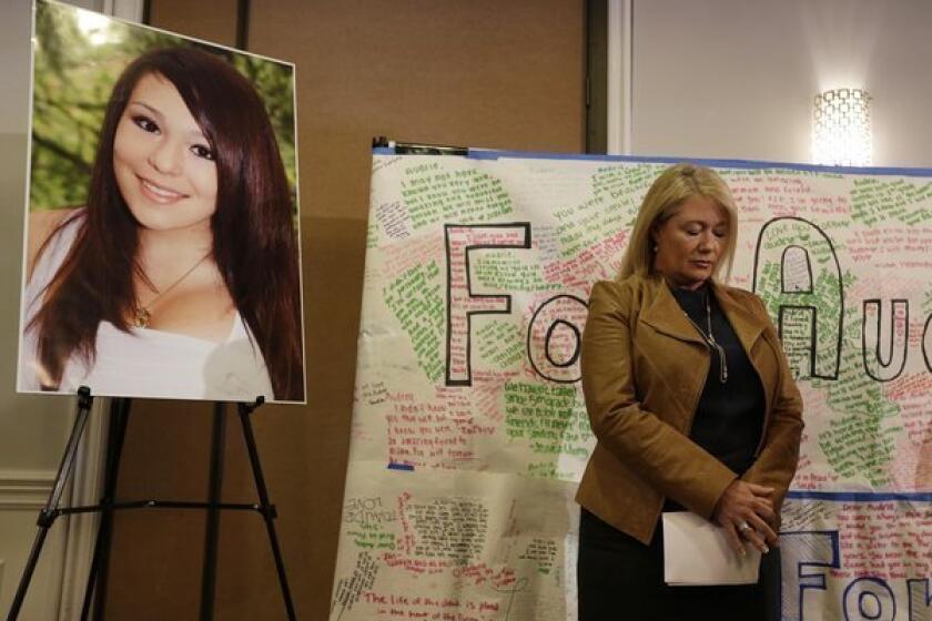 Sheila Pott, mother of Audrie Pott, who committed suicide after a sexual assault, stands by a photograph of her daughter and a message board during a news conference on Monday in San Jose.