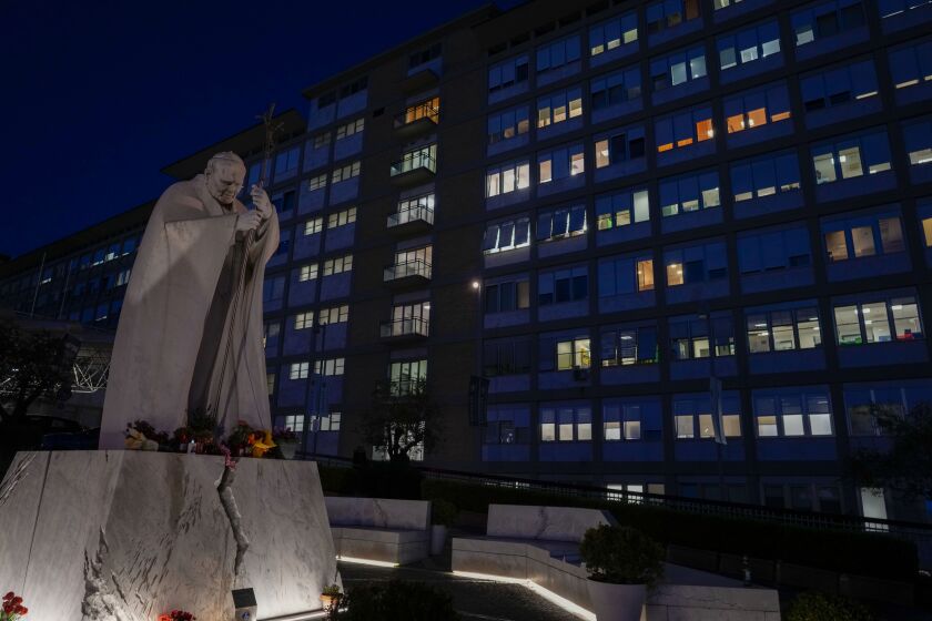 A statue of late Pope St. John Paul II is backdropped by the Agostino Gemelli hospital in Rome, Wednesday, March 29, 2023, after The Vatican said Pope Francis has been taken there in the afternoon for some scheduled tests. The Vatican provided no details, including how long the 86-year-old pope would remain at Gemelli University Hospital, where he underwent surgery in 2021. But his audiences through Friday were canceled, raising questions about Francis' participation during the Vatican's Holy Week activities starting Sunday.(AP Photo/Andrew Medichini)