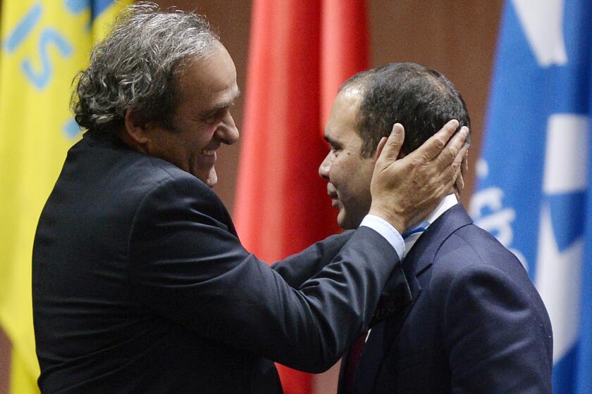 UEFA President Michel Platini, left, embraces Prince Ali bin al-Hussein after he withdrew from the FIFA presidential election on May 29.