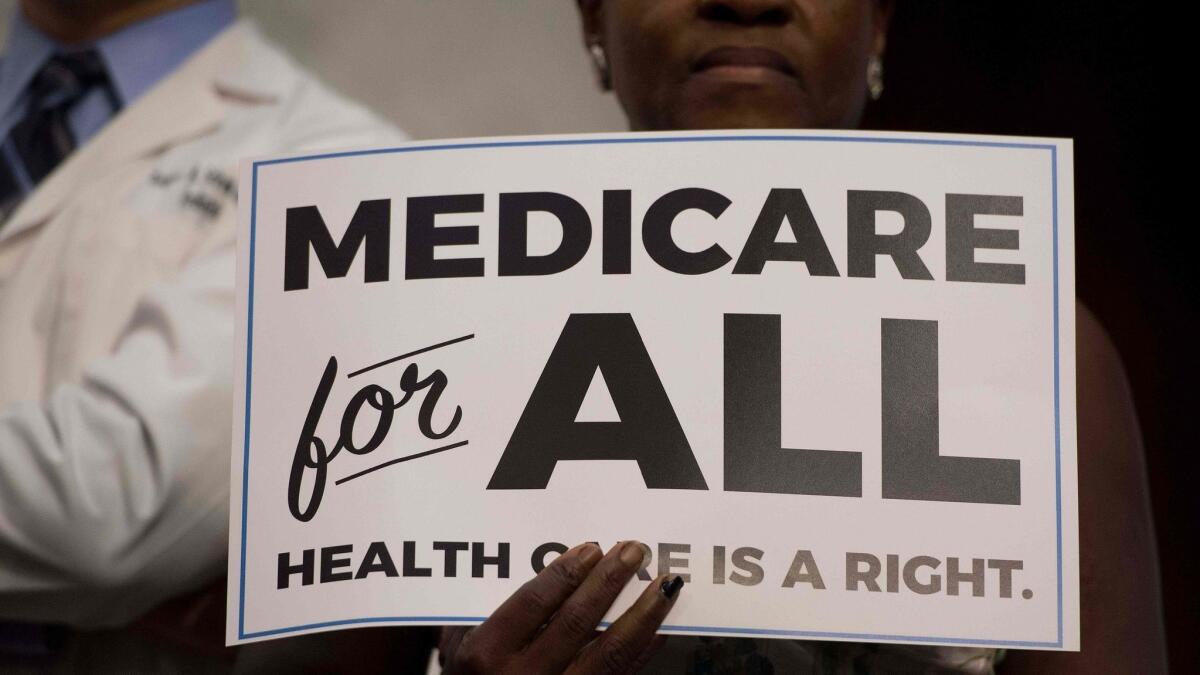 A member of the audience holds up a placard as Sen. Bernie Sanders (I-Vt.) discusses "Medicare for all" legislation in 2017.