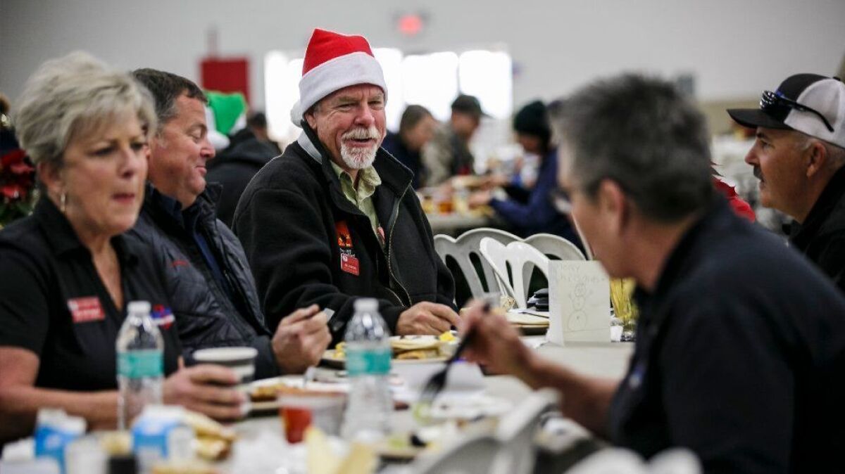 Jim Junette, food unit leader with the U.S. Forest Service, dines with co-workers Monday at the base camp for crews working the Thomas fire in Ventura, California, on Dec. 25.