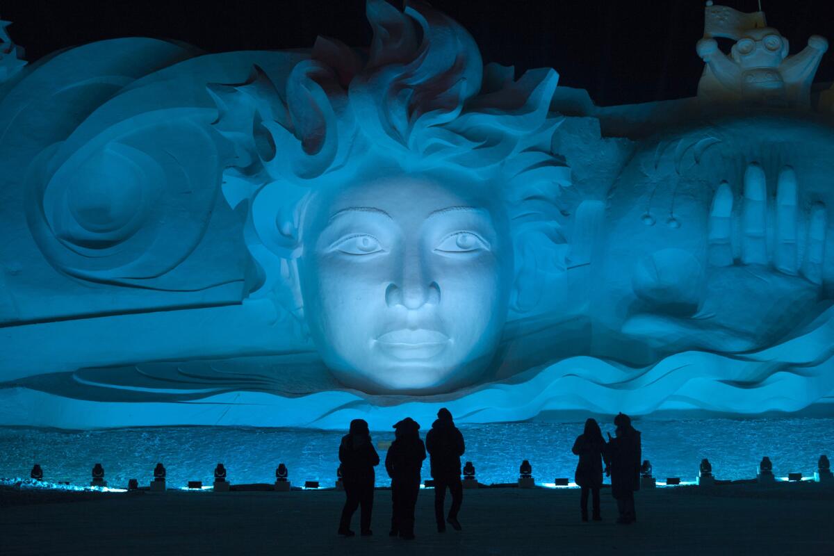 Tourists visit the Harbin International Snow Sculpture Art Expo at Harbin Sun Island park.