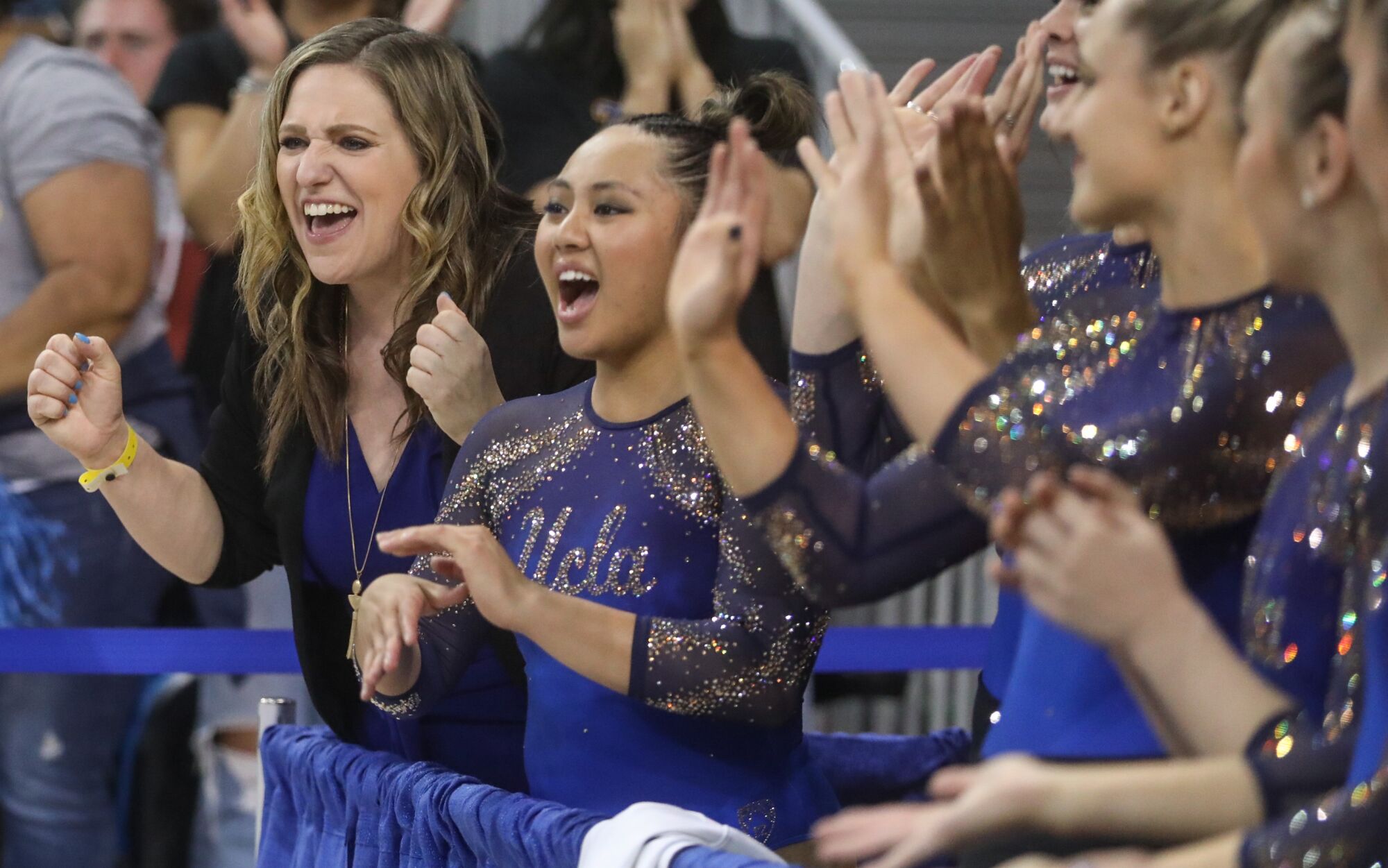   Janelle McDonald, entraîneure de gymnastique de l'UCLA, célèbre avec son équipe alors qu'elle participe à la région de la NCAA à Los Angeles