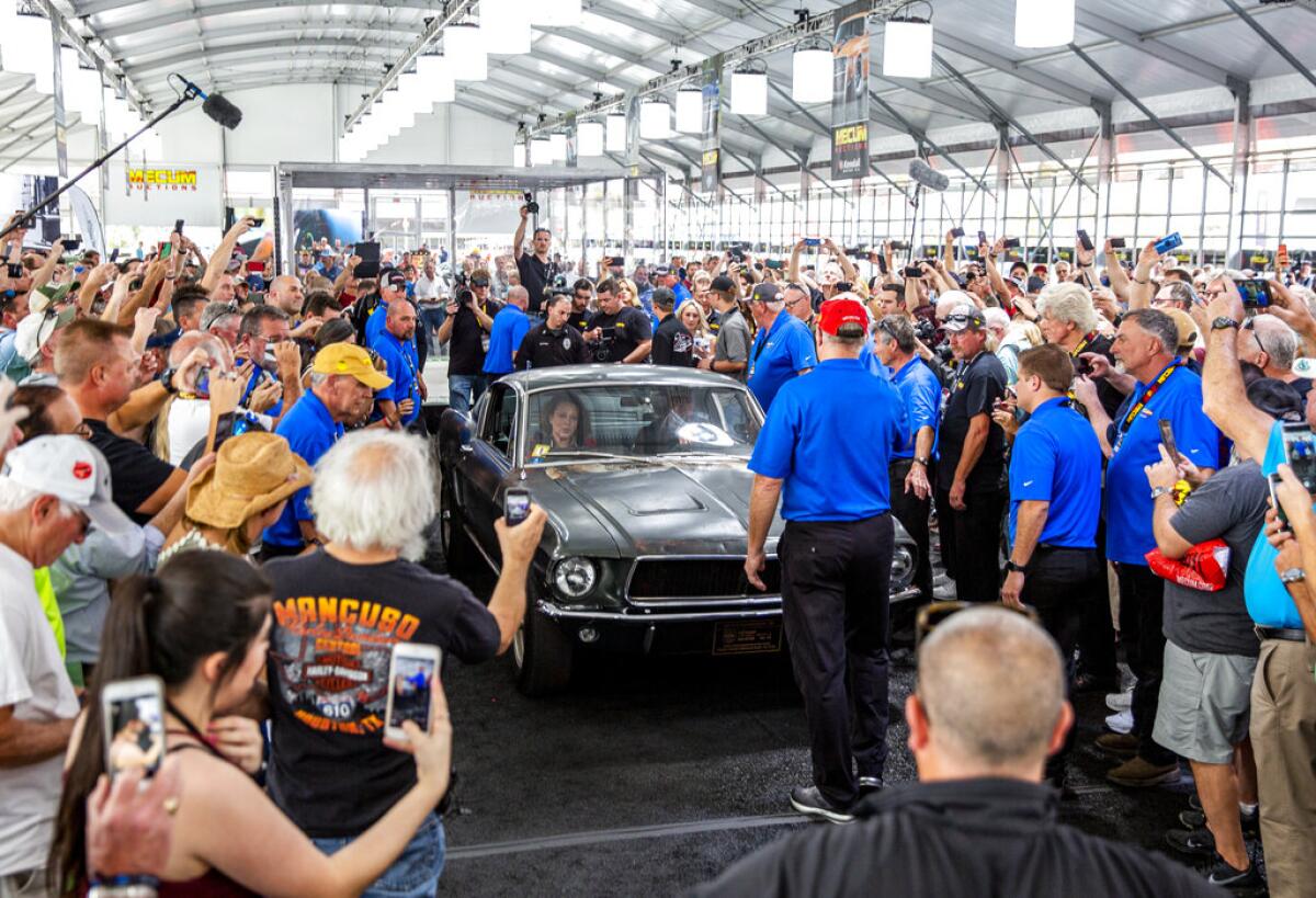 Una multitud rodea el Mustang GT utilizado en la película "Bullitt", estrenada en 1968, durante una subasta en Kissimmee, Florida, el viernes 10 de enero de 2020. (Patrick Connolly/Orlando Sentinel vía AP)