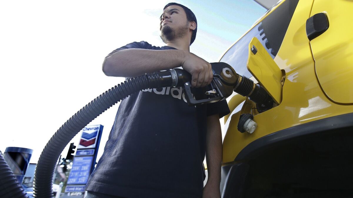 Cristian Rodriguez fuels his vehicle in Sacramento as battle lines are being drawn over a proposal to repeal an increase in the state's gas tax and vehicle fees.