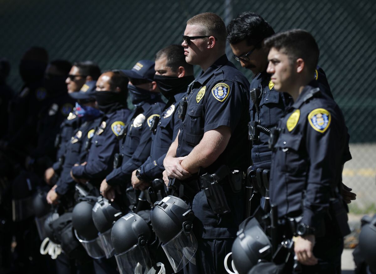 San Diego Police officers stand near police headquarters as Black Lives Matter protesters gather in the area June 14. 