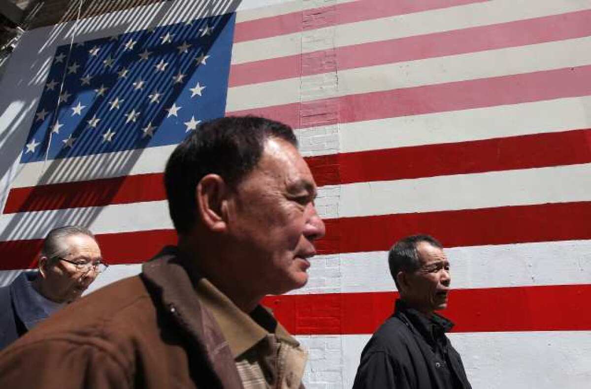 Pedestrians walk by an American flag mural in San Francisco, Calif. According to a study released last week by the Pew Research Center, Asian Americans are now the largest group of new immigrants to the United States bringing the population of Asian Americans to a record 18.2 million.