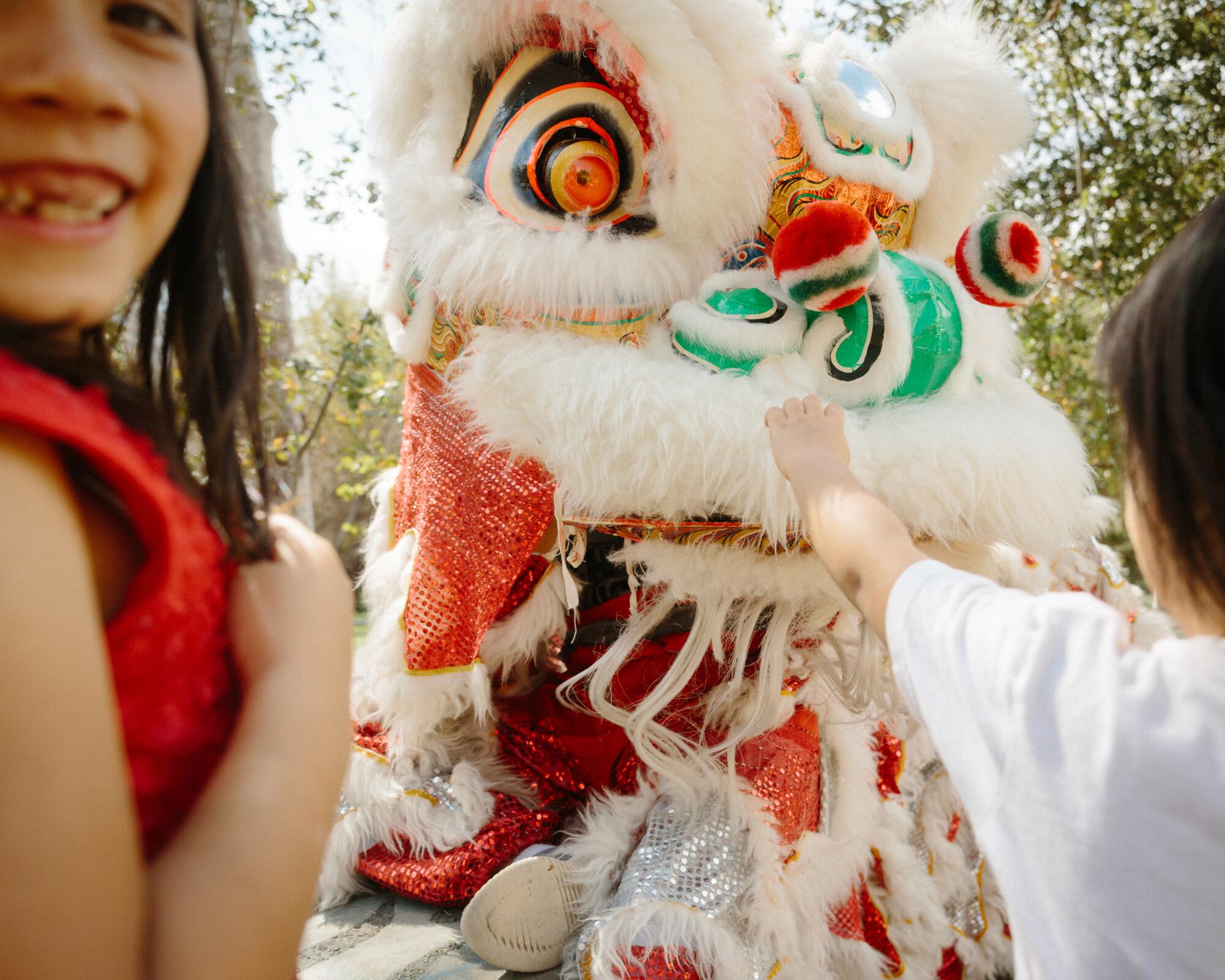 A smiling child with a Chinese lion puppet.