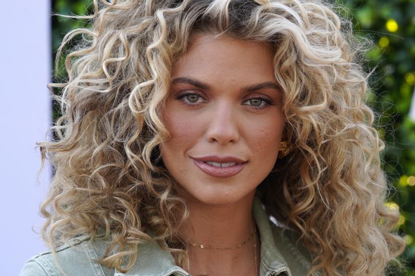 A young woman with curly blond hair